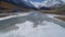 Aerial. River running through white mountains valley