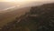 Aerial rotate around rocks sticking out the Peak District National Park during an amazing sunset