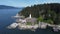 Aerial rotating drone shot of Lighthouse Park with rocky seashore and pine forest in Vancouver