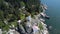 Aerial rotating drone shot of a lighthouse on a rocky sea shore located in Lighthouse Park Canada