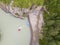 Aerial of a rubber motor boat sailing from a blue plastic pier on a green river in the mountains