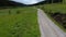 Aerial rural forest road and meadow at a cloudy day - video footage