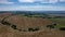 Aerial of a rural landscape with green leafy trees across the valley