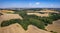 Aerial of a rural landscape with green leafy trees across the valley