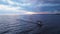 Aerial of a sailing boat on the blue tranquil seascape captured at sunset