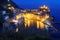 Aerial scenery of beautiful Vernazza at dusk with reflections of lights on peaceful wate