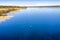 Aerial scenic view: unidentified person ice skating on crystal clear frozen lake in Northern Scandianvia. Clear skies, blue ice,