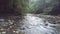 Aerial shooting from flying drone over stony river flowing in summer forest