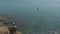 Aerial shooting of a man standing on a cliff above a clear mediterranean sea