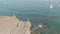 Aerial shooting of a young man standing on a cliff above a clear sea