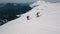 Aerial shot active backpacker snowboarding tourist climbing on winter mountain surrounded by snow