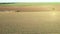 Aerial shot of agricultural field with two tractors pulling a disc harrows over agricultural field, farmland