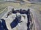 Aerial shot of an ancient ruined castle in the middle of crop field