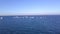 Aerial shot of approaching to a Group of small sail boats in calm sea waters.