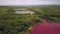 Aerial shot with artificial lakes in industrial zone, one has pink water