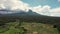 Aerial shot of Bali Volcano, Drone Shot, flying backwards over rice fields and terraces. Cloudy sky.