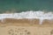 Aerial shot of the beautiful foamy ocean waves meeting the sands on the beach