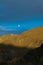 Aerial shot of a beautiful mountain landscape on a cloudy sky and a white moon backgrounds