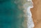 Aerial shot of the beautiful ocean waves meeting the sands on the beach