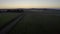 Aerial shot of a beautiful Swedish landscape with a road and a hut at the late sunset