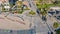 An aerial shot of a bike lane with people riding bikes at the beach surrounded sand and palm trees at Santa Monica Beach