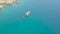 Aerial shot blue sea with sailing boat and swimming people in turquoise water. Drone view people bathing around boat