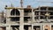 Aerial Shot of the Building in the Process of Construction. Labor working in big construction site.