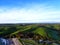 Aerial shot of buildings in the Cornish coastline with a green hill behind it, Scilly Isles