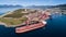 Aerial shot of a cargo ship anchoring in port terminal and loading iron ore