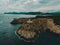 Aerial shot of a cliff side coast of Mallorca, with a lighthouse and the vast expanse of the sea