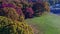 Aerial shot of colorful trees and blue birds flying by in a park on   Long Island, New York, USA