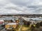 Aerial shot of country town buildings, street, cars, clouds and the skyline in Armidale, Australia