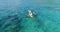 Aerial shot of couple kayaking in turquoise sea during summer day