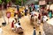 Aerial shot of crowd of people lining up for a camel ride in a dusty pit with multiple camels standing, shot in Jaipur