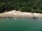 Aerial shot of the Da Barra Do Sahy sandy beach with vacationers near the clear sea