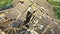 Aerial shot of the destroyed roof of an abandoned cattle barn.