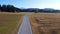 Aerial shot with drone of road with motorcycle driving towards alps