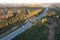 Aerial shot of an ecoduct highway with traffic and the horizon on a sunny evening