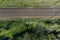 Aerial shot of empty parallel railways surrounded by grass in the daylight