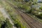 Aerial shot of empty parallel railways surrounded by grass in the daylight