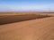 Aerial shot of a farmer plowing stubble field