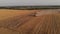 Aerial shot: few combines harvest weat at sunset.