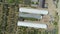 Aerial shot: Flying over the greenhouses. agriculture industry scene. Summer season time.