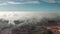 Aerial shot. Flying on a sunny, clear day over volumetric texture thunderstorm clouds. At the bottom of the forest and