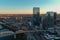 Aerial shot of glass skyscrapers and office buildings in the city skyline at sunset with cars driving on the street