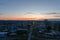 Aerial shot of glass skyscrapers and office buildings in the city skyline at sunset with cars driving on the street