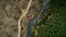 Aerial shot of gravel road in mountain forest