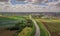 Aerial shot of green farmlands in a small town under a cloudy sky