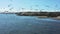 Aerial shot of a group of birds flying over the sea  with ships at harbor on a clouded sky