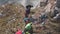 Aerial shot of a group of climbers on top of a mountain pulling a rope.